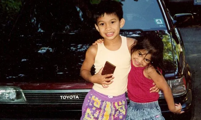 Two children in front of a Toyota Camry